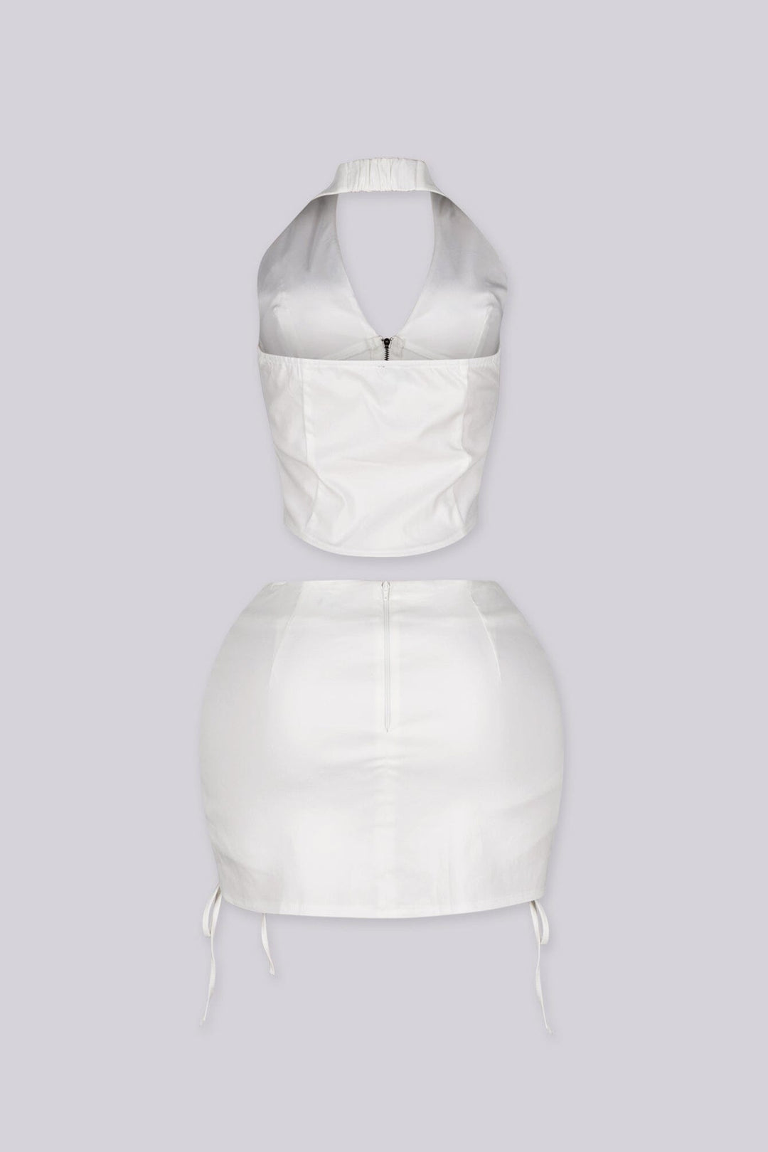 Cropped halter top with lace up panel at the sides featuring metal zipper closure at center front
Paired with a matching mini skirt with lace up panel at the sides