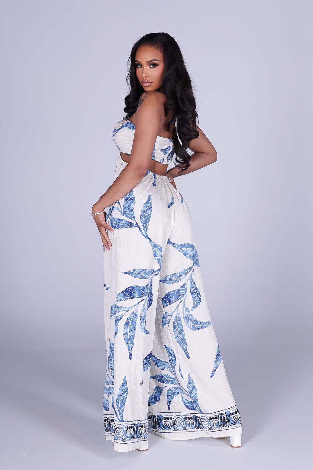 Blue leaf print wide leg halter jumpsuit featuring gathered center bust detail with deep plunge notch
Side waist cut out with smocked back detail