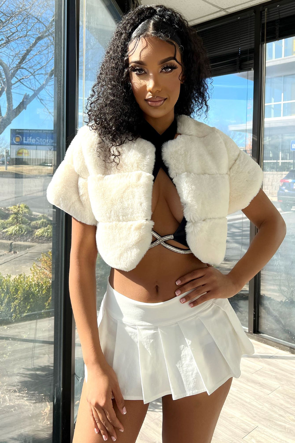 White Lavish faux fur cropped cover up on model showing short sleeves and textured panels