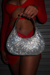 EDGE — silver rhinestone-embellished shoulder bag held by a model in a red outfit